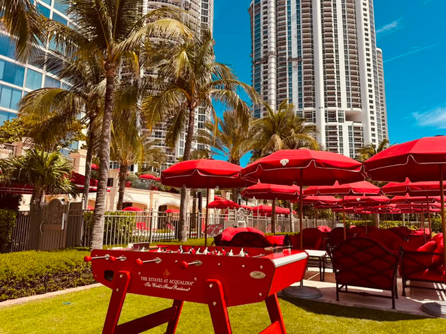 Red foosball table among the outdoor umbrellas and buildings at The Estates at Acqualina