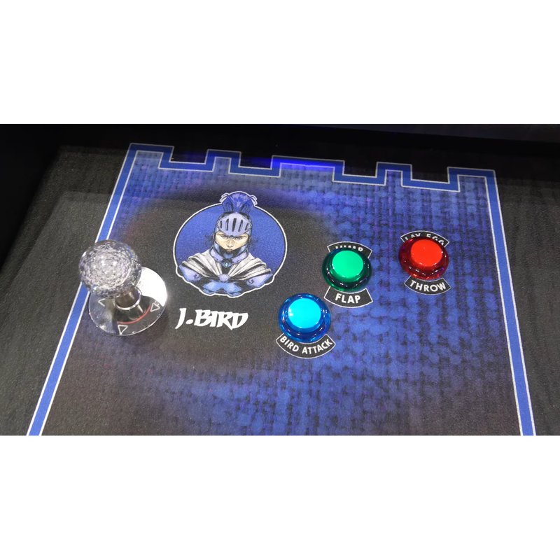 Alan-1 Avian Knights arcade cabinet control panel, player one station, showing the ball top joystick and the three LED buttons labelled BIRD ATTACK in blue, FLAP in green and LAY EGG THROW in red, with the J-Bird knight character art and blue castle border.