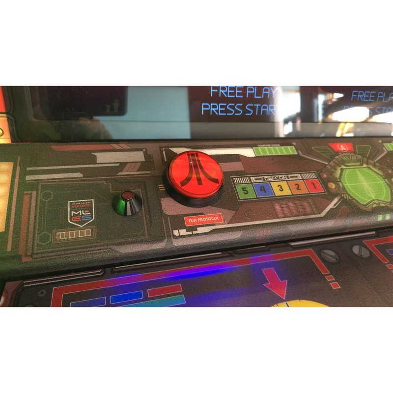 Illuminated red Atari Fuji fire button on the Missile Command Recharged Pro control panel, beside the DEFCON scale and Major League eSports badge.