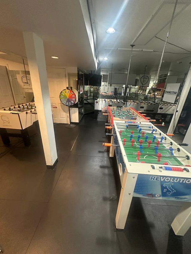 Customer room with multiple foosball tables, including a Roberto Sport Revolution table