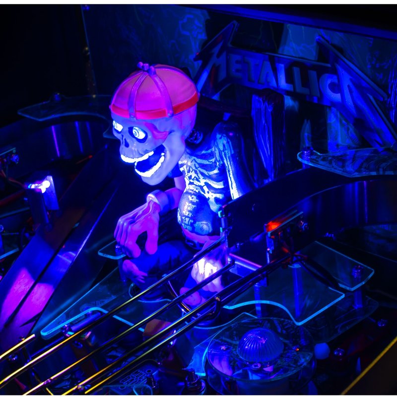Stern Metallica Remastered Premium Pinball Machine featuring illuminated RGB Sparky skull figure and skeleton with glowing eyes in electric chair, commercial pinball game detail view.
